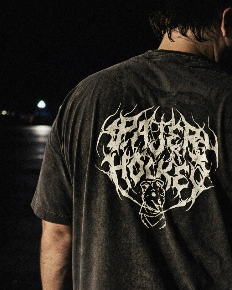 Person wearing a black t-shirt with a white bear design on the back at night.